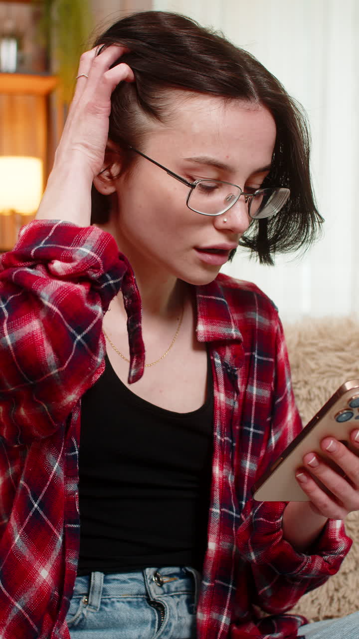 Young woman upset after reading bad news on smartphone reacting to failure in game or test result