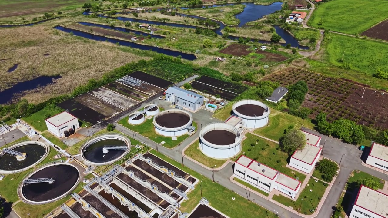 Cruise above wastewater. Aerial view of treatment plant infrastructure. High vantage point capturing entire wastewater treatment complex and natural surroundings
