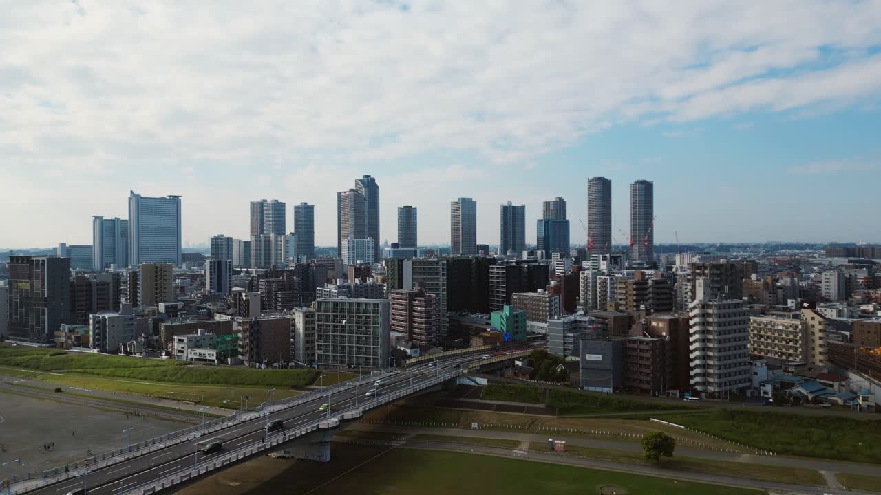 Drone flies forward over Musashi Kosugi bridge showing modern Tokyo view