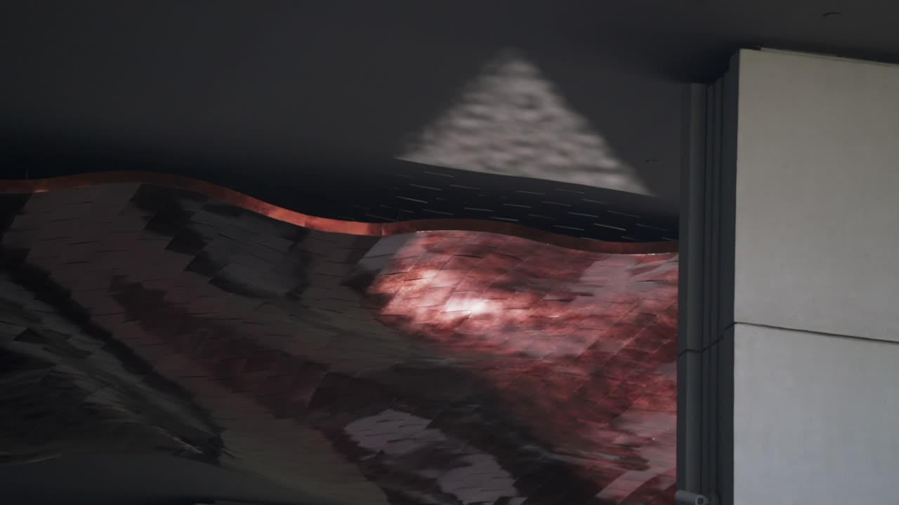 이 추상 영상에서 매혹적인 분홍색 반사가 물 위에서 춤을 추고 있습니다.