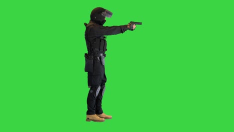 unidad táctica de la policía apuntando con una pistola de mano en una pantalla verde, llave de croma