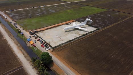 Airplane-reveal-shot-in-the-middle-of-lush-green-paddy-fields