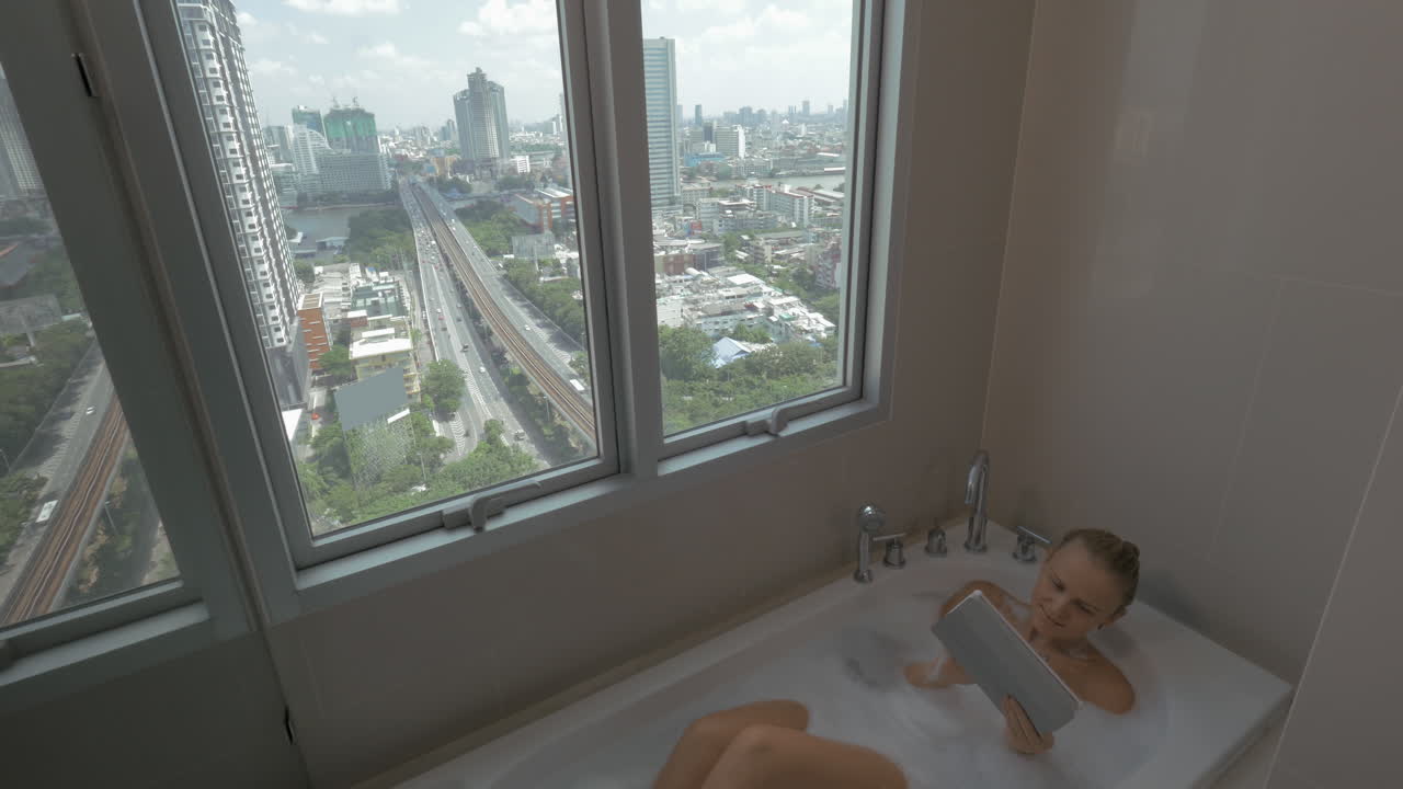 목욕 을 하는 동안 태블릿 컴퓨터 를 사용 하는 여자