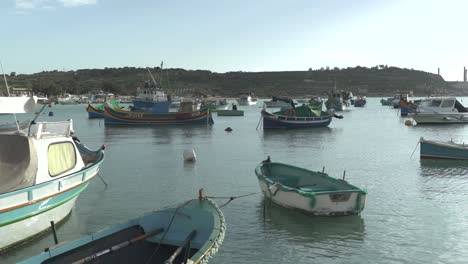 port of marsaxlokk with traditional fishing boats in bay on a sunny day in malta