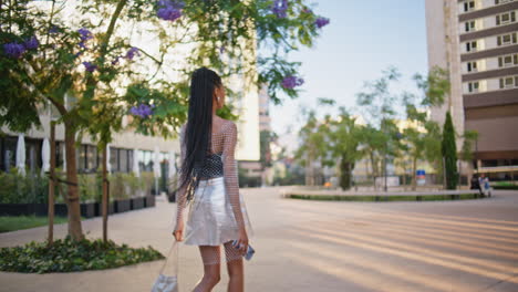 relaxed brunette walking city back view.  girl enjoying summer stroll