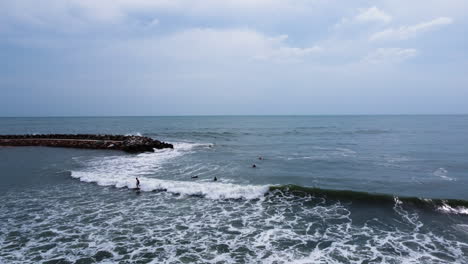 a slow zoom out from the waves near the shore of mui ne, where a surfer is riding a wave