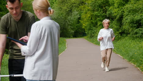 elderly woman exercising with assistance in a park