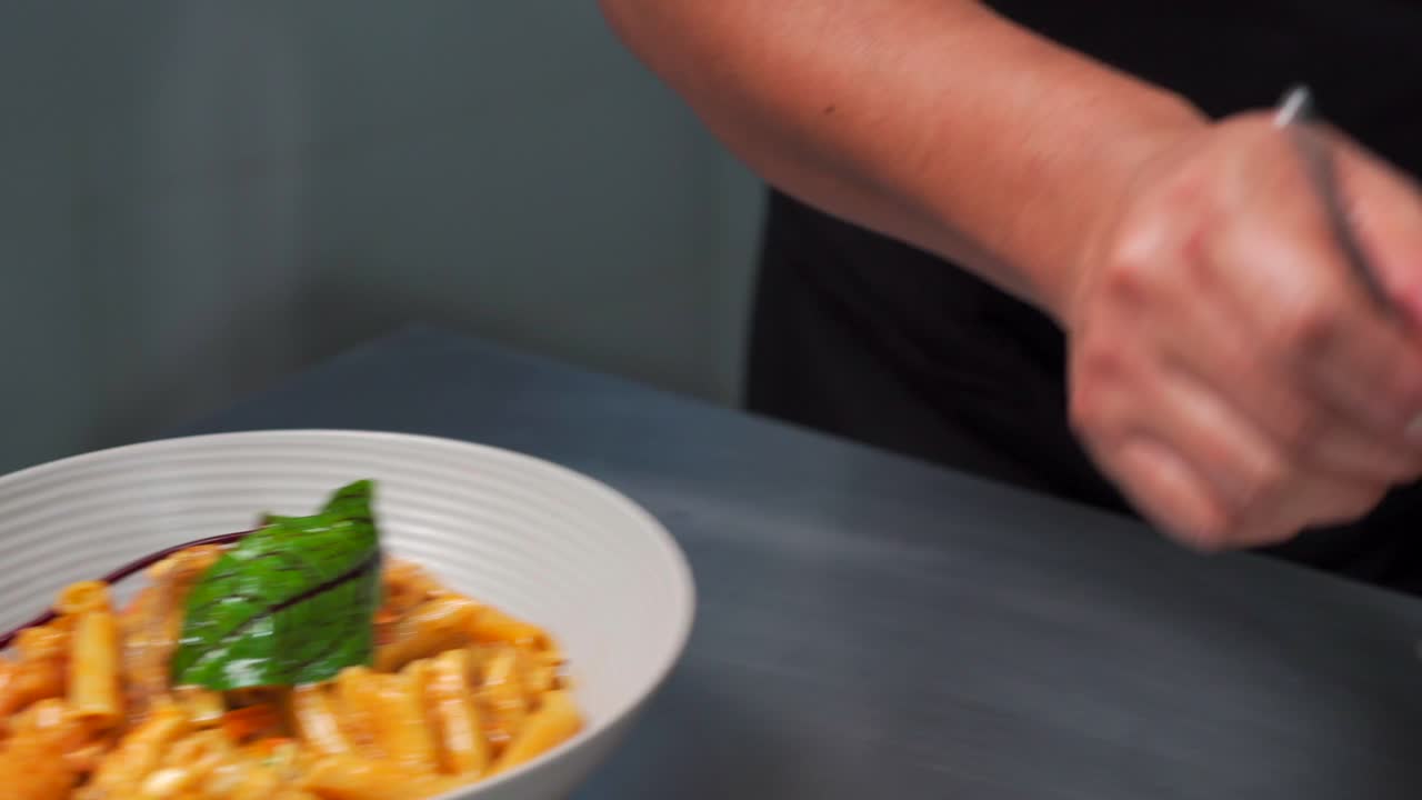 Chef decorating pasta with shrimps dish recipe at italian latin restaurant penne cannelloni macaroni with cheese tomato gourmet special leaf garnish