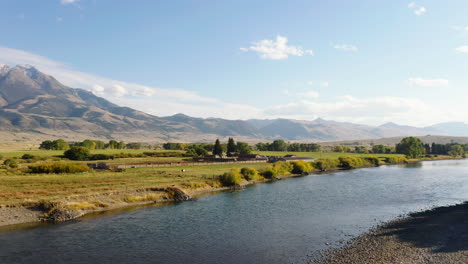 Aerial-footage-of-river-flowing-through-rural-countryside-at-golden-hour