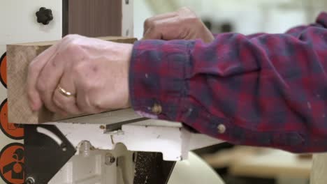 a carpenter using a sander in a furniture factory in slow motion