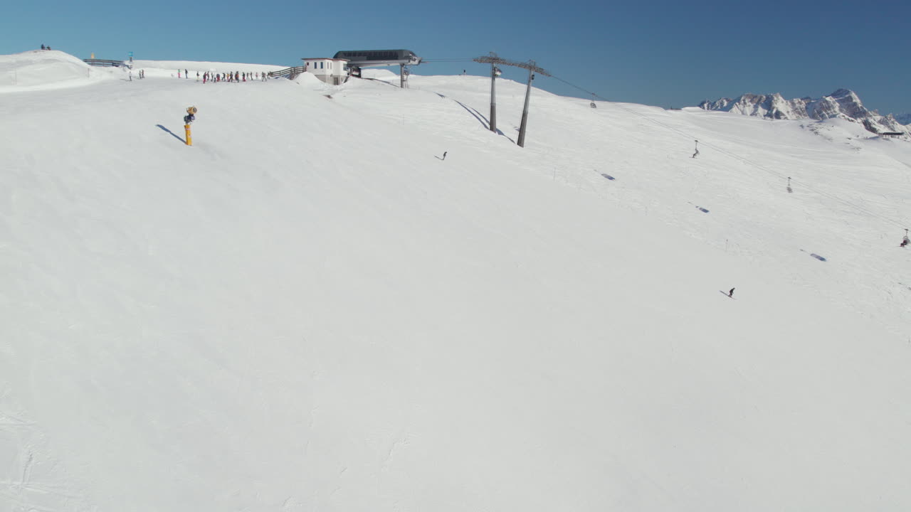 снежный склон с горнолыжным лифтом и лыжниками в саальбахе-хинтерглемме, австрия - снимок с дрона