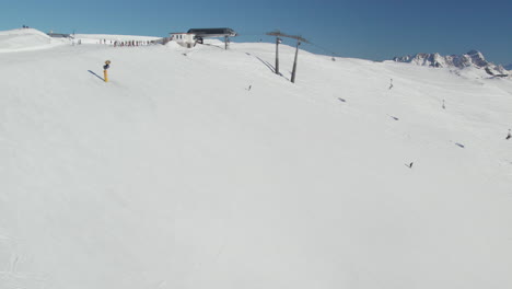 Snowy-Slope-With-Ski-Lift-And-Skiers-In-Saalbach-Hinterglemm,-Austria---Drone-Shot