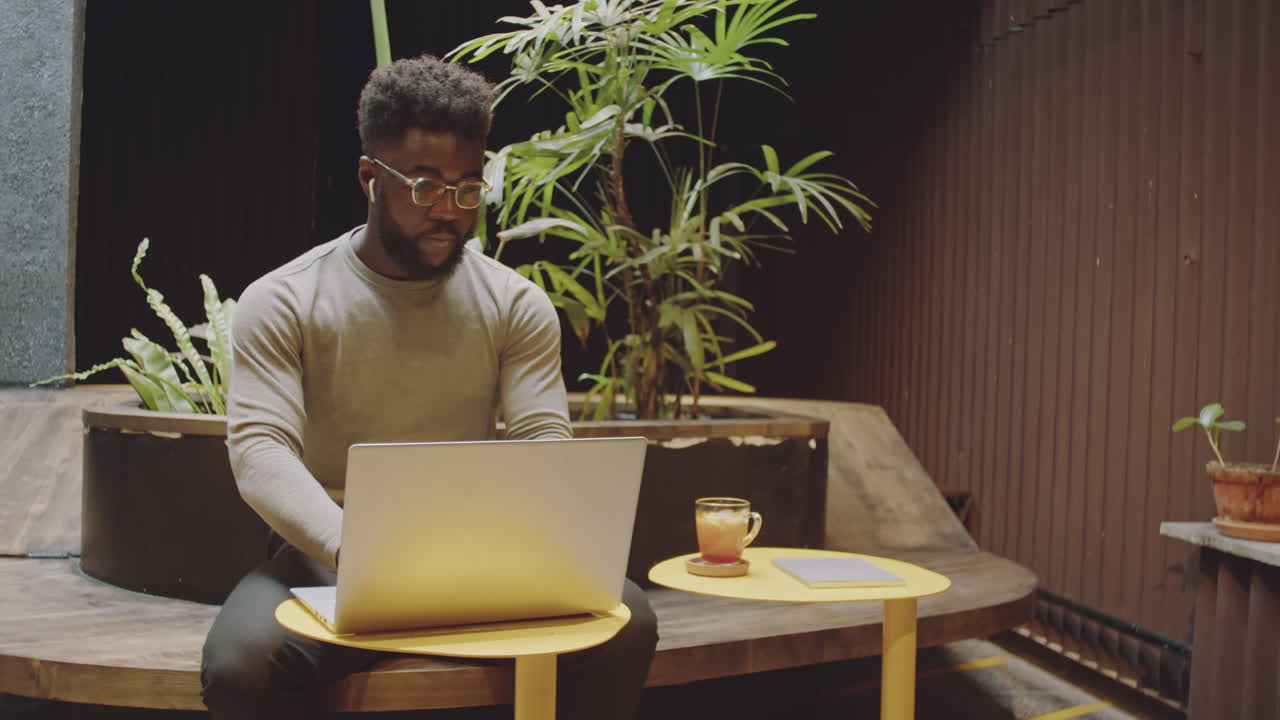Man working on laptop in a cafe