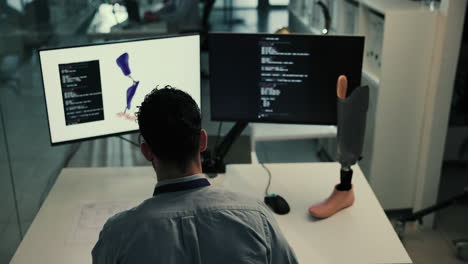 man working at computer with prosthetic leg