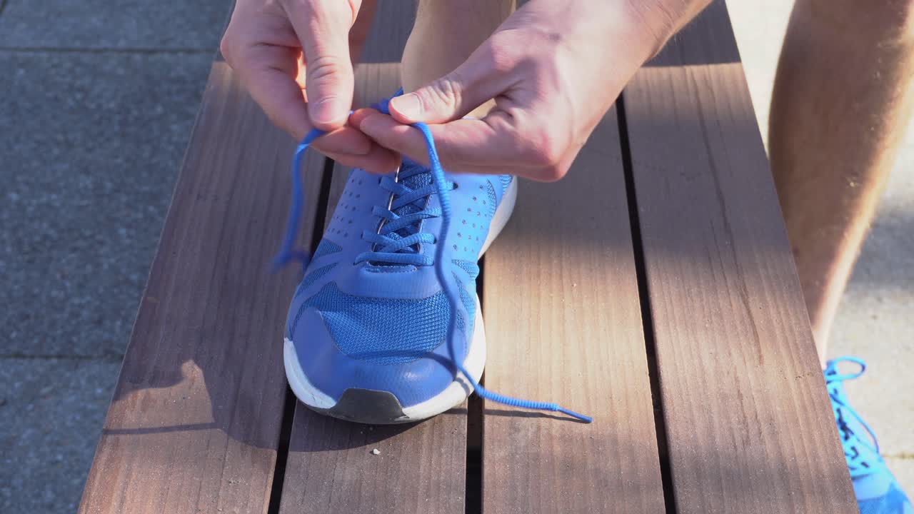 Un corridore si sta allacciando le scarpe
