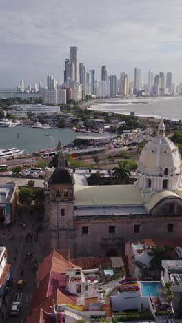 aerial view of the cathedral of san pedro claver with the modern buildings of cartagena in the background, located in colombia. vertical video
