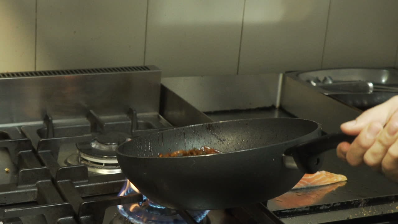 Cooking salmon with noodles in a wok