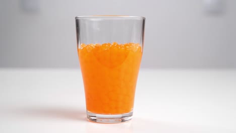 orbeez - balls that grow in water pour into a glass of water.