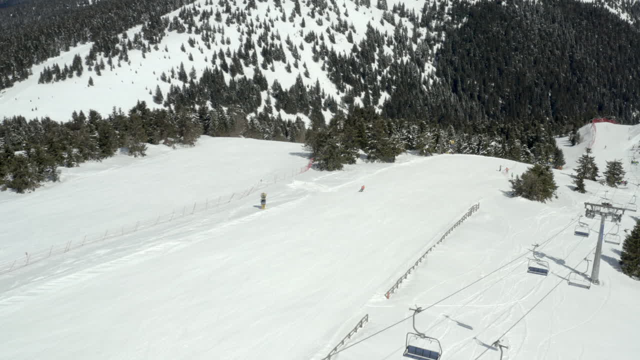 Stazione sciistica su una montagna innevata con impianti di risalita e sciatori