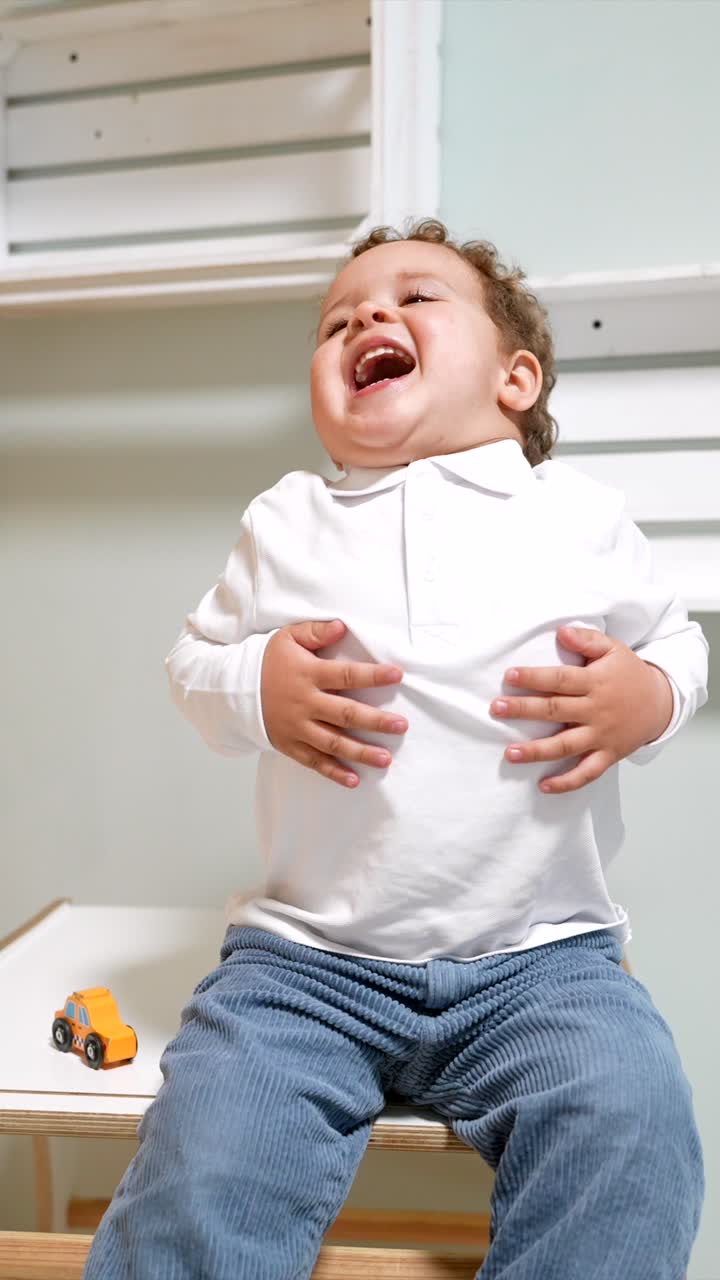 Happy Toddler Boy Smiling and Laughing with a Toy Car