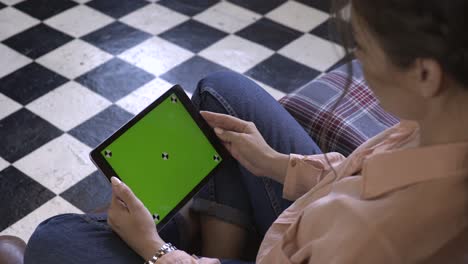 woman using tablet with green screen