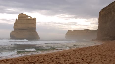 mysterious atmosphere at twelve apostles monumental limestone rocks off the shore of port campbell national park, with sea mist and rolling waves, by the great ocean road in victoria, australia.