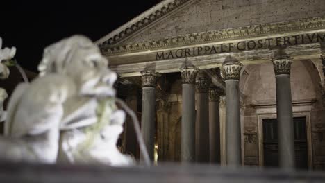 Water-fountain-outside-Pantheon-in-Rome,-Italy-at-night-with-rack-focus-from-fountain-to-building