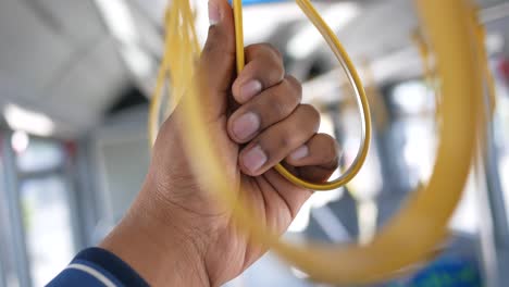 person holding a bus handrail