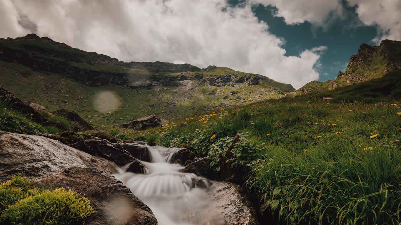 timelapse con una pequeña cascada de montaña que sale de un lago glaciar
