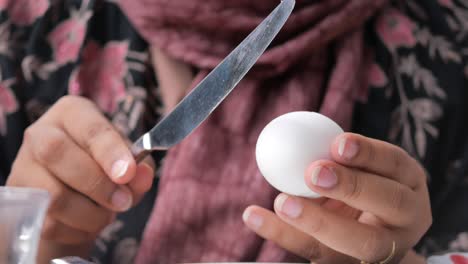 woman peeling a hard boiled egg