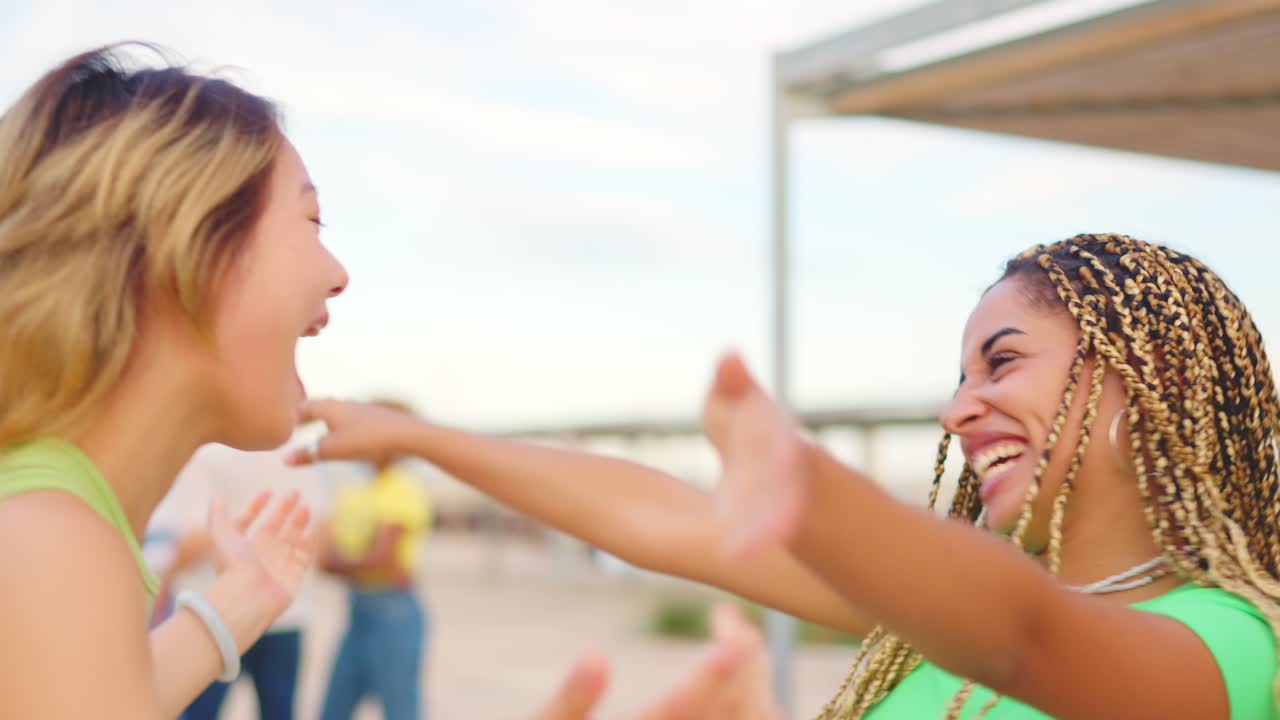 Happy friends embracing and laughing on the beach