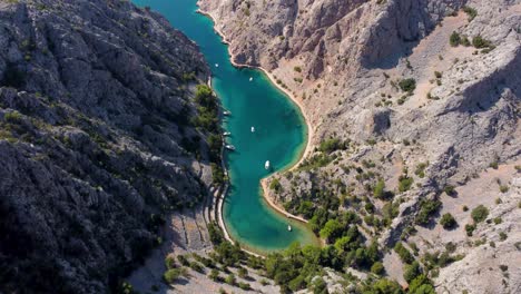 Drone-flyover-beautiful-bay-of-Zavratnica-on-a-sunny-summer-day,-scenic-nature-near-town-of-Jablanac-Croatia