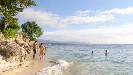 tourists at the holiday resort with rocky shoreline in moalboal, cebu island, philippines. static shot