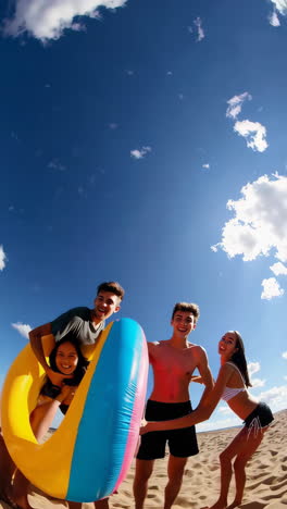 young friends having fun with inflatables on a sandy beach