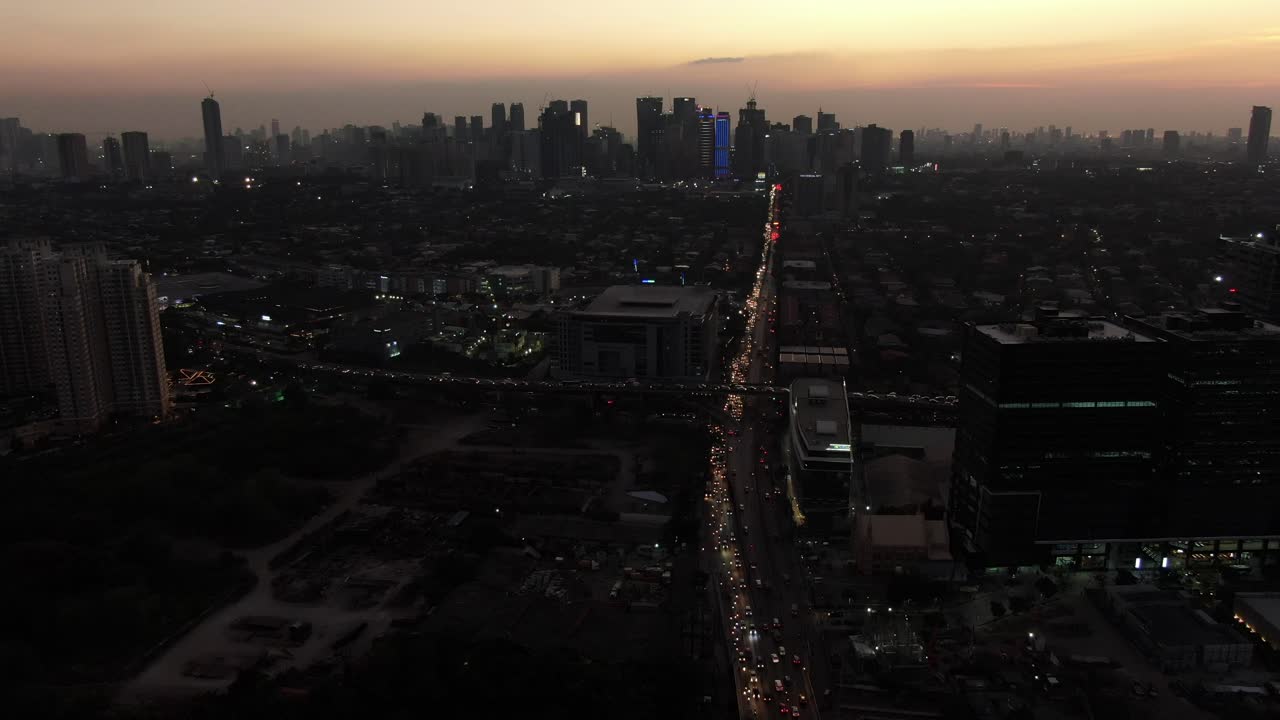 una toma aérea cinematográfica de la concurrida carretera arterial de color naranja y el cruce del paso elevado durante el crepúsculo