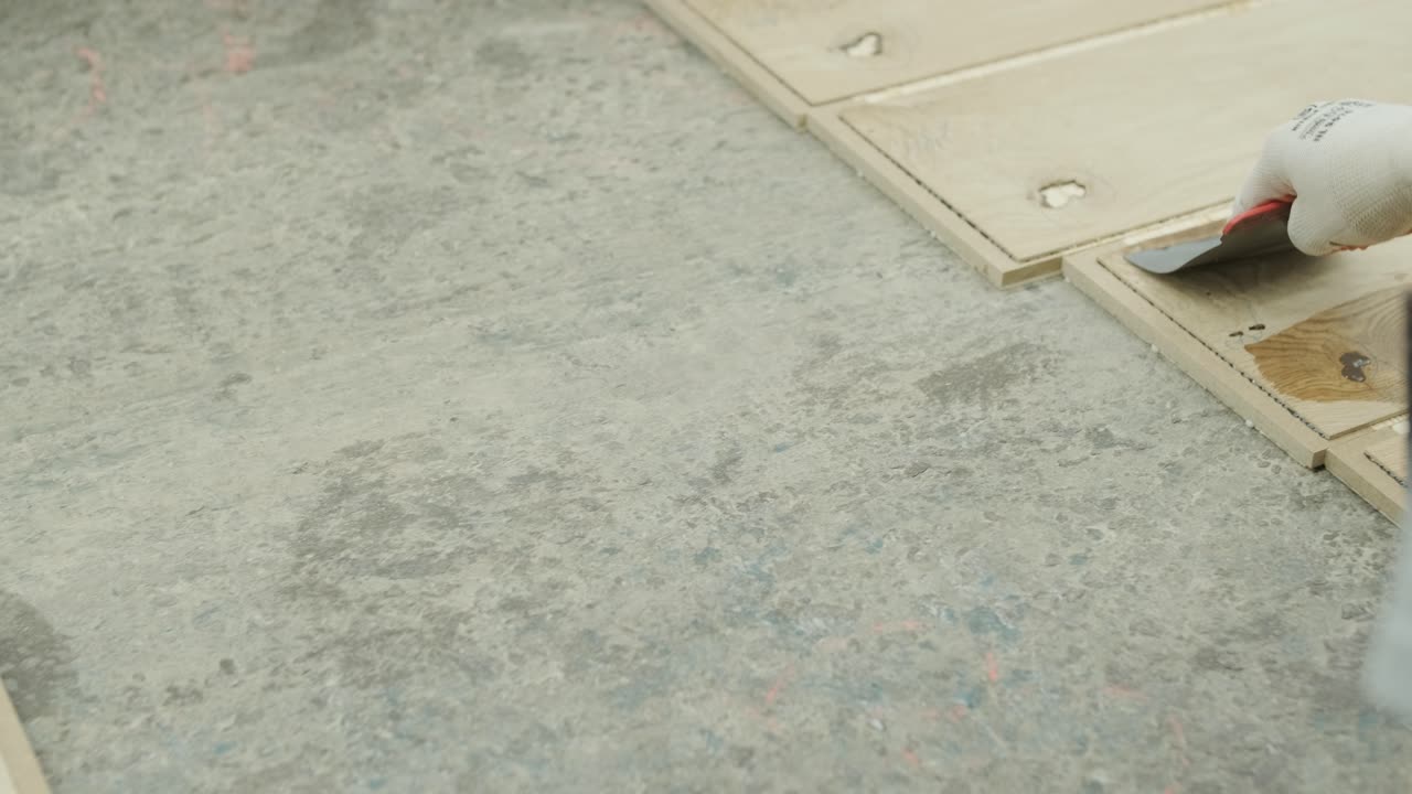 Worker Applying Wood Filler to Planks in a Factory