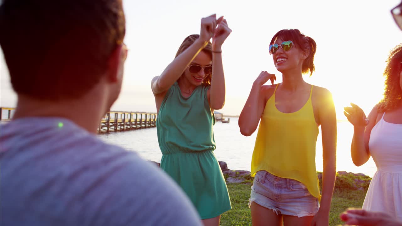 jóvenes multiétnicos tocando la guitarra en la playa