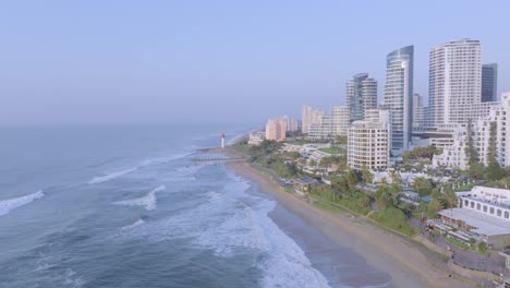 costa de umhlanga con olas y edificios modernos, cielo despejado, vista aérea