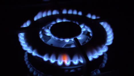 gas stove turned on and off with blue flames fire in the dark