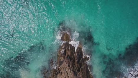 Bird's-eye-view-of-waves-meeting-rocky-Australian-coastline