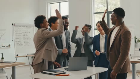 diverse business team celebrates success with high-fives in office meeting