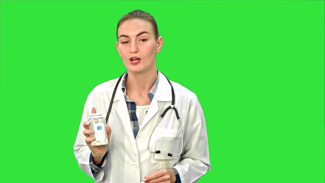 예쁜 여성 의사는 녹색 화면, 크로마 키에 카메라를 위해 약을 설명하고 광고
