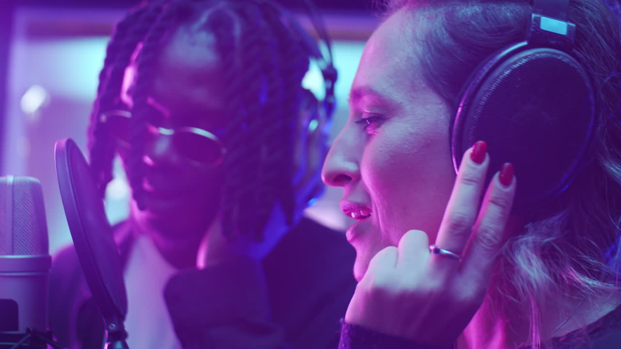 mujer caucásica y hombre negro grabando una canción juntos