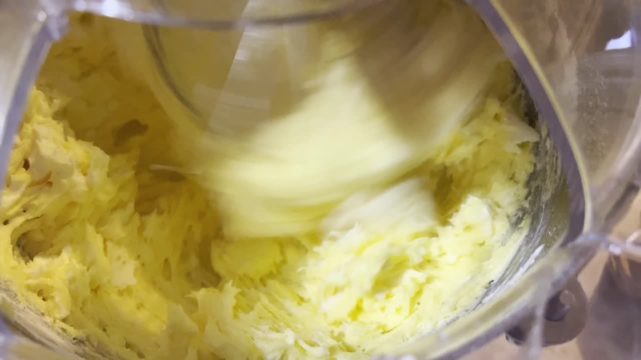 mantequilla batida en masa para pastel con un mezclador de pie, cerca