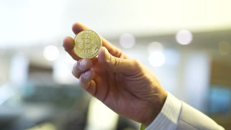 hand holding a bitcoin coin