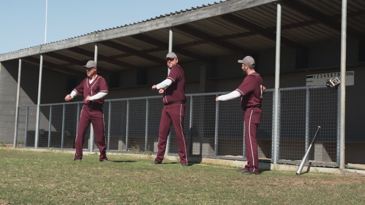Baseball players warming up on field, stretching arms before game