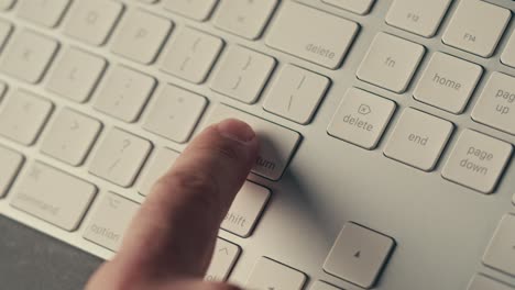 el dedo presionando la tecla de borrar en un teclado de computadora