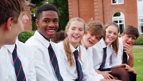 teenage students in uniform socializing outside school buildings