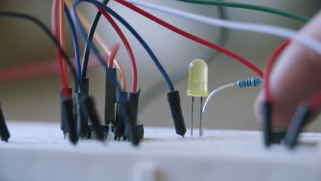 close up of a yellow led diode getting turned on by a switch