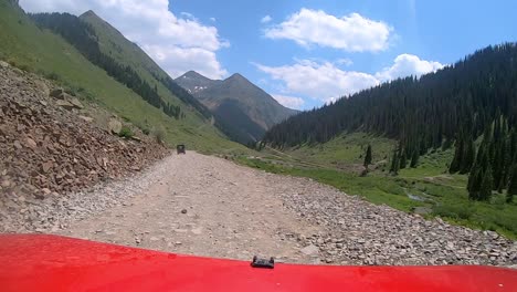 punto de vista sobre el capó rojo del vehículo en un sendero estrecho fuera de la carretera que sigue el valle del río animas en las montañas de san juan en colorado